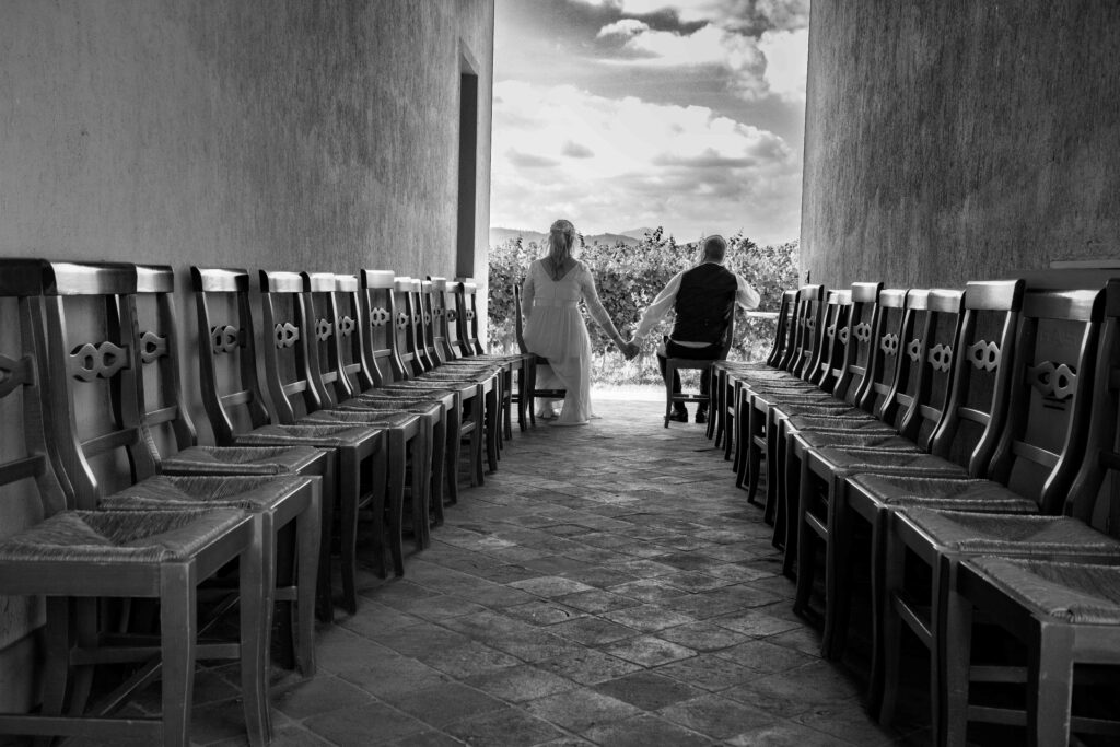 gli sposi tenendosi per mano guardano verso il vigneto