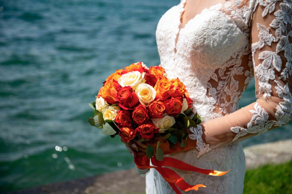 sposa con in mano il bouquet in riva al lago
